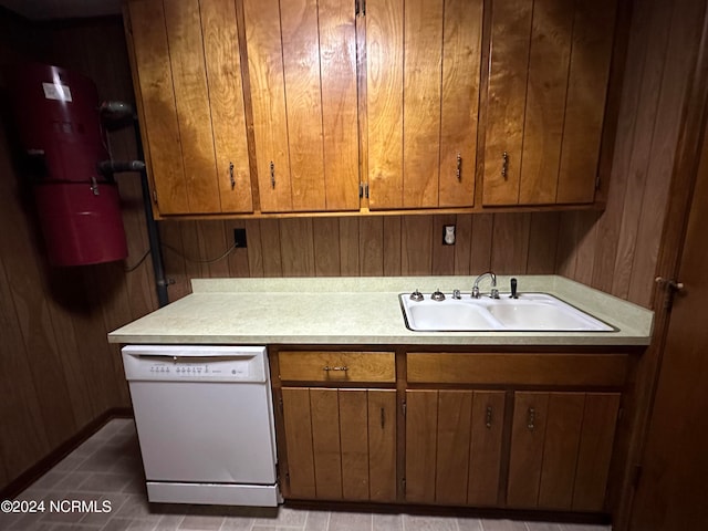 kitchen with sink, wooden walls, and white dishwasher