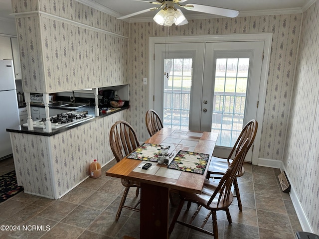 dining room with ceiling fan, dark tile flooring, sink, ornamental molding, and french doors