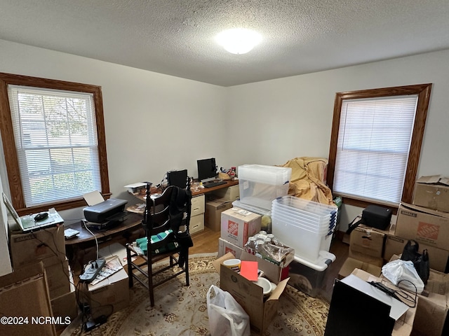 office area with hardwood / wood-style floors and a textured ceiling