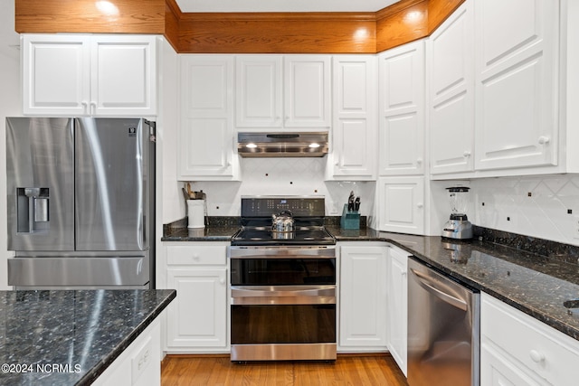 kitchen with stainless steel appliances, light wood-type flooring, white cabinetry, exhaust hood, and decorative backsplash