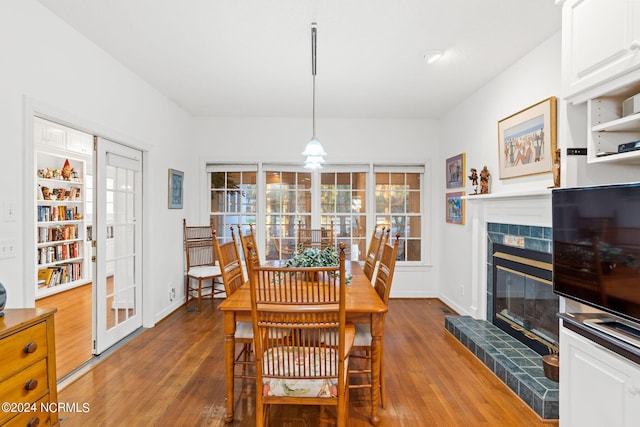 dining area featuring dark wood-type flooring and a tile fireplace