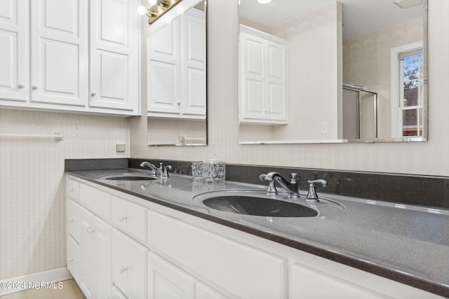 bathroom with an enclosed shower, vanity, and tile patterned floors