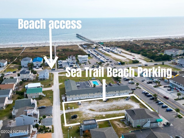 birds eye view of property featuring a beach view and a water view