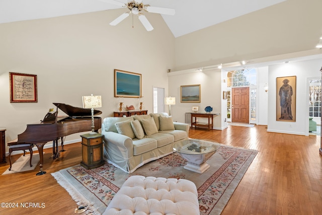 living room with hardwood / wood-style floors, ceiling fan, and high vaulted ceiling