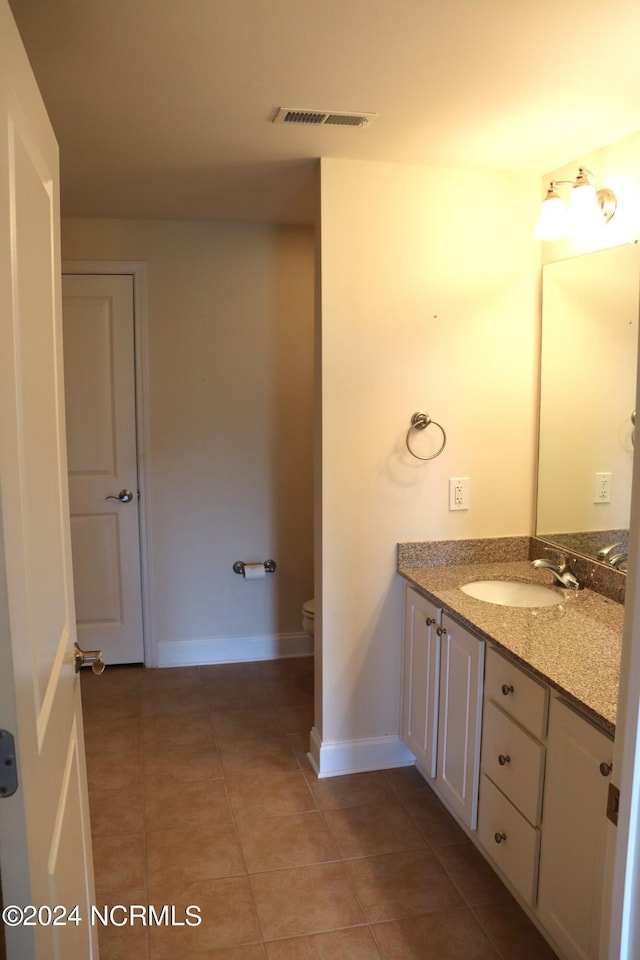 bathroom with toilet, tile patterned flooring, and vanity