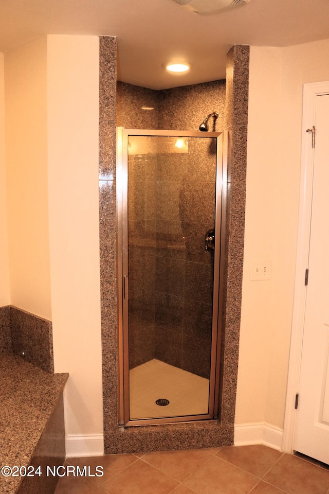 bathroom featuring a shower with door and tile patterned floors