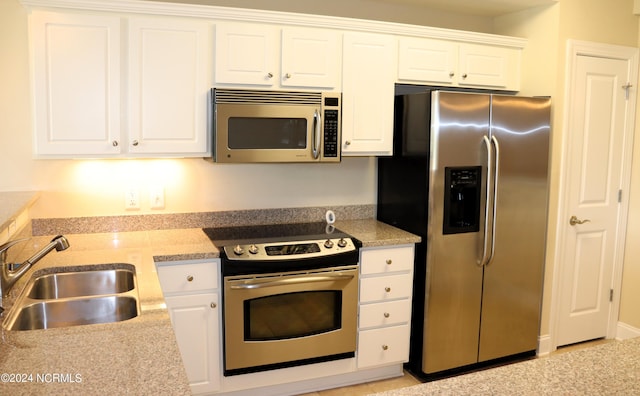 kitchen featuring white cabinets, appliances with stainless steel finishes, and sink