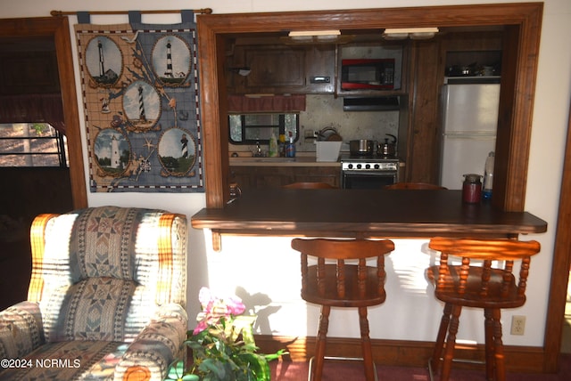 bar with ventilation hood, electric range oven, and white refrigerator