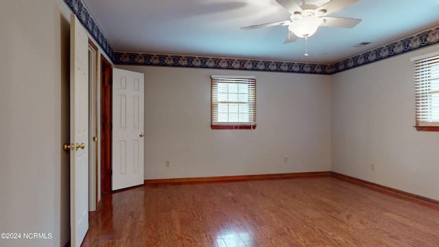 unfurnished room featuring ceiling fan and dark wood-type flooring