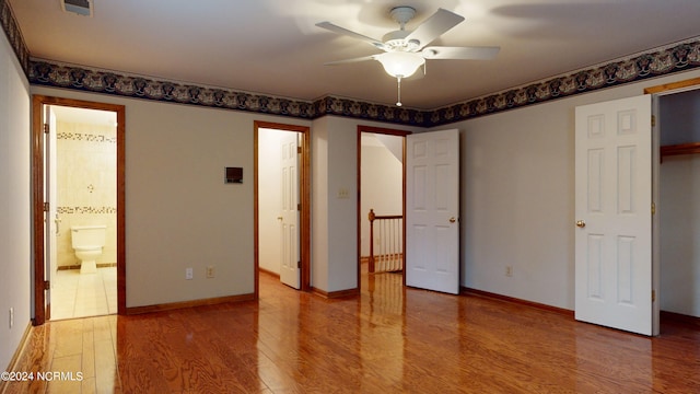 unfurnished bedroom featuring ceiling fan, a closet, light tile floors, and connected bathroom