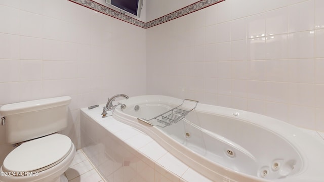 bathroom featuring tiled bath, tile walls, and toilet