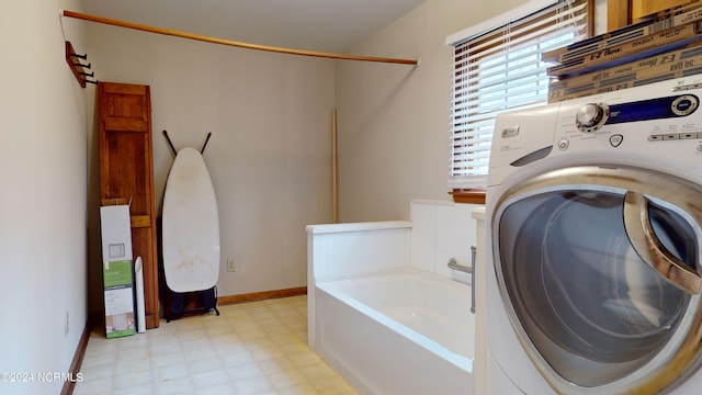 laundry area with light tile floors and washer / clothes dryer