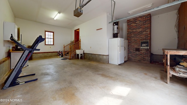 garage with a garage door opener and white fridge