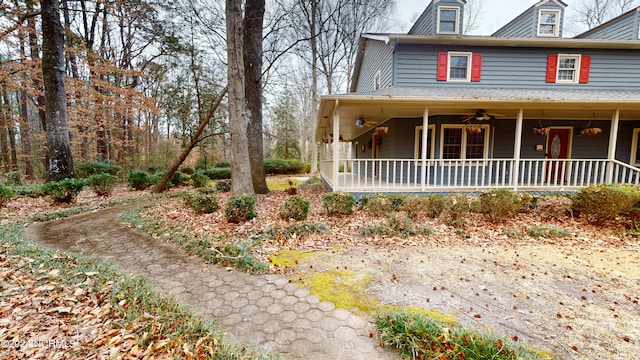 view of side of property featuring ceiling fan and a porch