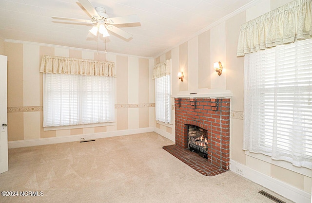 carpeted living room featuring crown molding, ceiling fan, and a fireplace