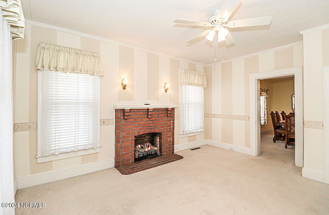 carpeted living room featuring ceiling fan, crown molding, and a brick fireplace