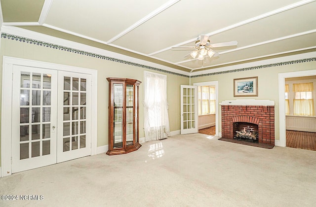 unfurnished living room featuring light colored carpet, vaulted ceiling, ceiling fan, french doors, and ornamental molding