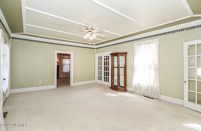 carpeted spare room featuring ceiling fan, crown molding, and french doors