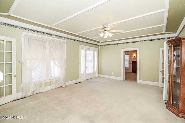 empty room featuring crown molding, vaulted ceiling, light colored carpet, and ceiling fan