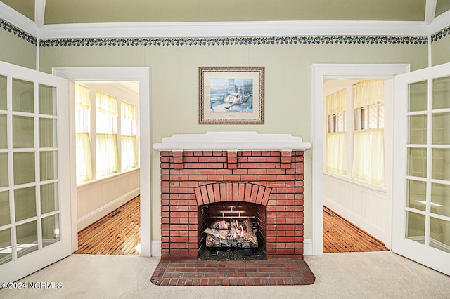 unfurnished living room featuring carpet flooring, ornamental molding, and a fireplace