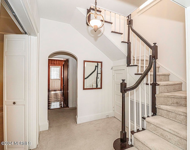 stairs featuring light carpet and vaulted ceiling