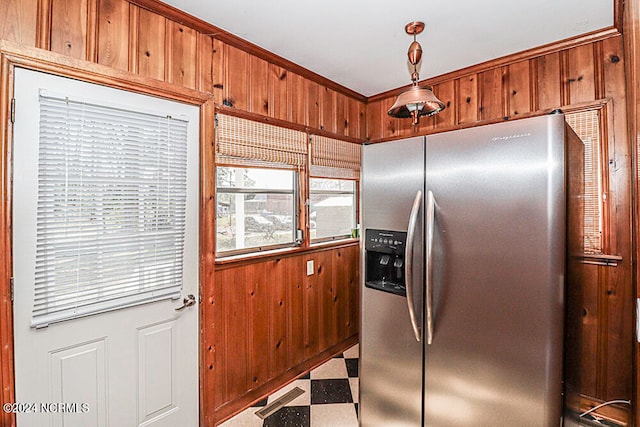 kitchen featuring stainless steel fridge with ice dispenser, hanging light fixtures, and light tile flooring