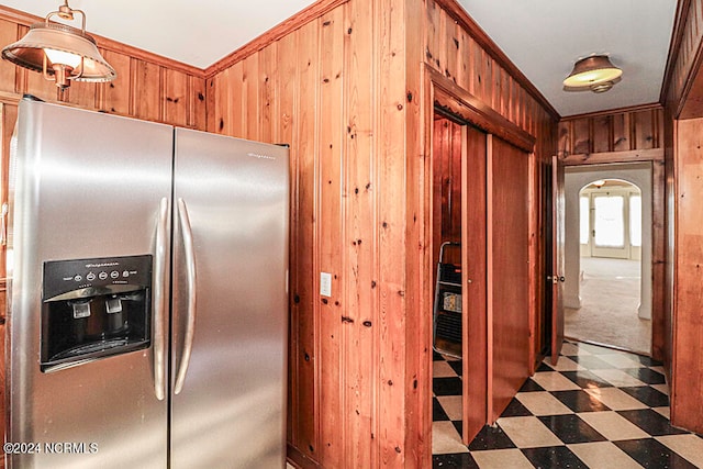 kitchen with stainless steel fridge, pendant lighting, dark tile floors, and crown molding