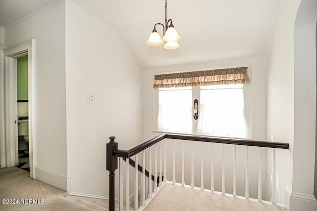 stairway featuring vaulted ceiling, light carpet, and a chandelier