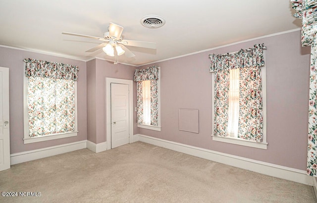 carpeted empty room with crown molding and ceiling fan