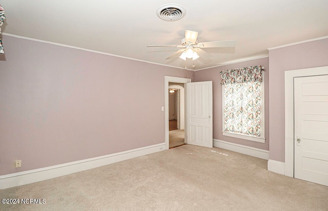 carpeted spare room featuring ceiling fan and ornamental molding