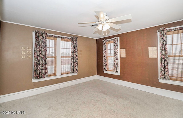 carpeted empty room with ceiling fan and plenty of natural light