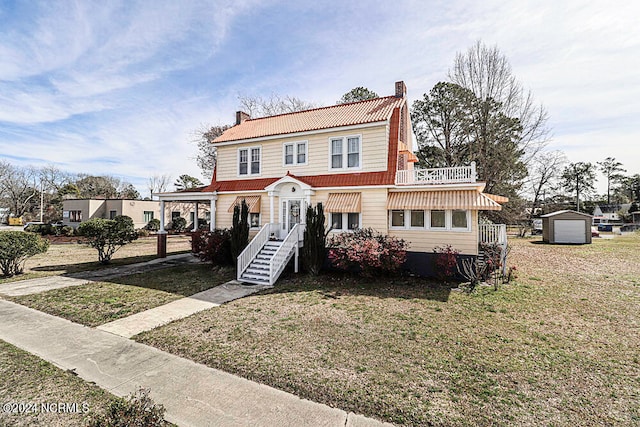 view of front of home featuring a front lawn, an outdoor structure, and a garage