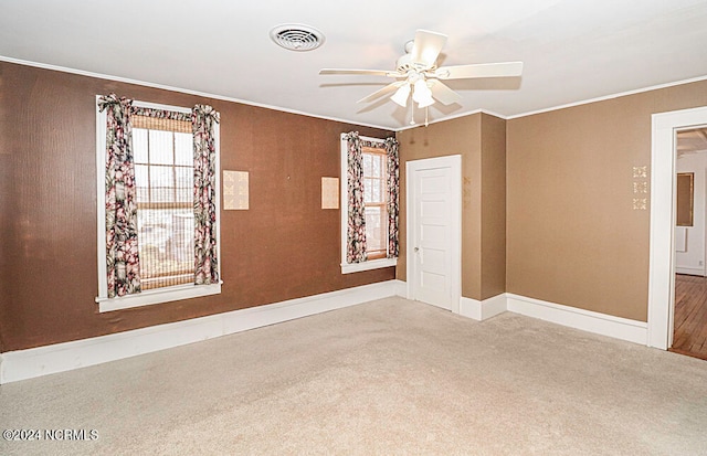 spare room with light carpet, ceiling fan, and crown molding