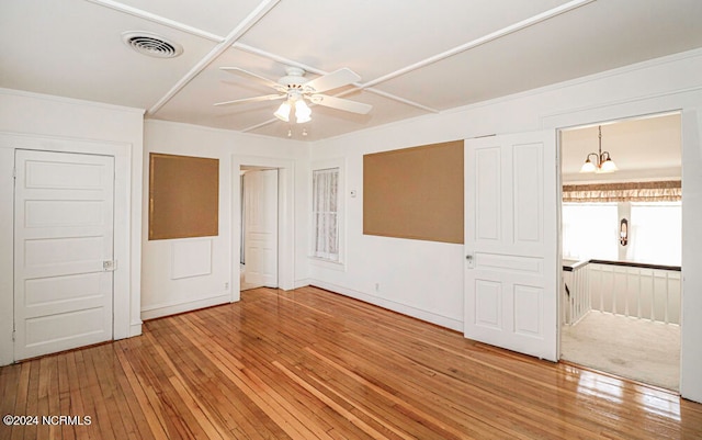 carpeted empty room with ceiling fan with notable chandelier