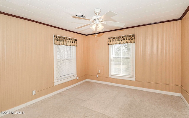 carpeted empty room with ceiling fan and crown molding