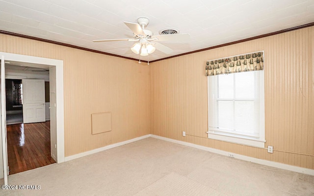 spare room with ceiling fan, ornamental molding, and light wood-type flooring