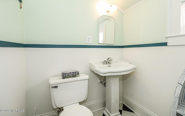 bathroom featuring crown molding and toilet