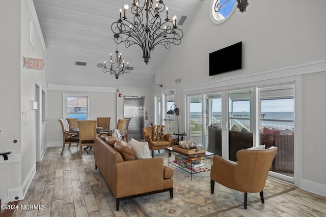 living room with an inviting chandelier, hardwood / wood-style floors, and high vaulted ceiling