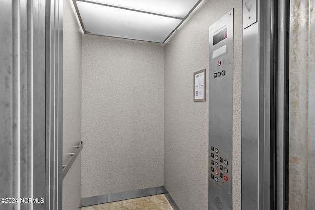 interior space with elevator and tile patterned flooring