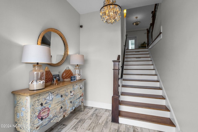 staircase featuring hardwood / wood-style flooring and a chandelier