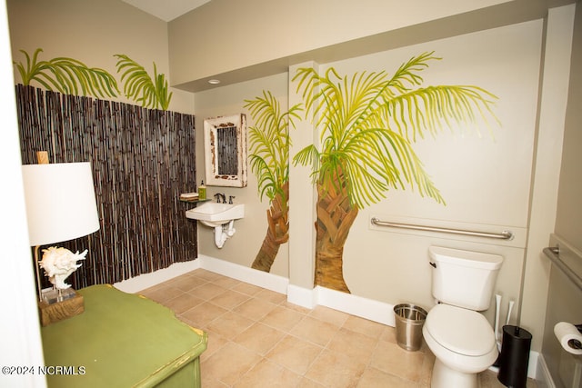 bathroom with toilet, sink, and tile patterned floors