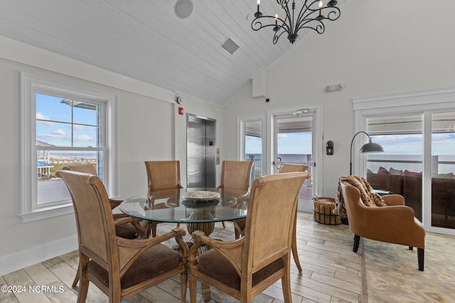 dining room with high vaulted ceiling, elevator, a water view, light hardwood / wood-style flooring, and a chandelier