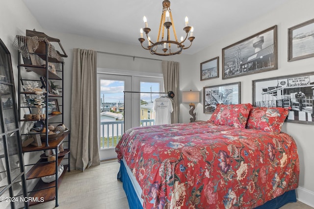 bedroom with access to exterior, a notable chandelier, and light wood-type flooring