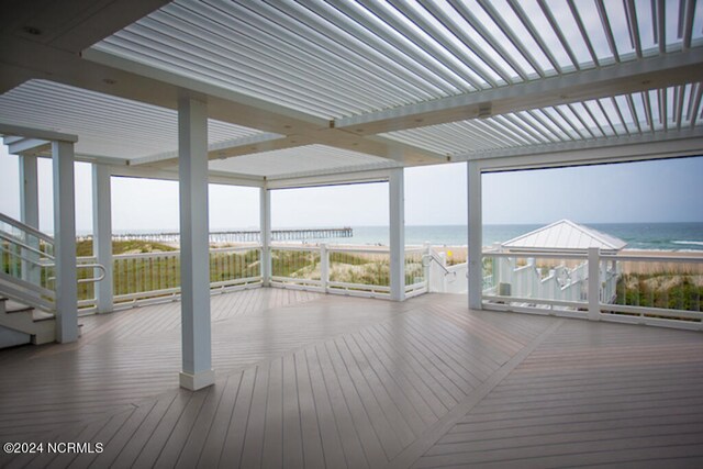 wooden deck featuring a view of the beach and a water view