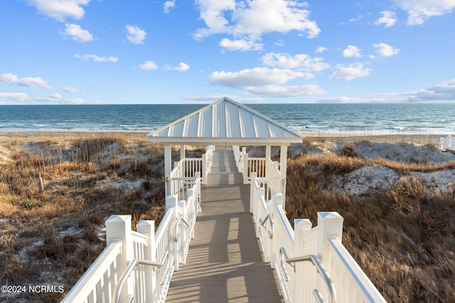 view of community featuring a beach view, a gazebo, and a water view