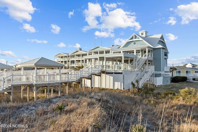 back of property with a wooden deck and a gazebo