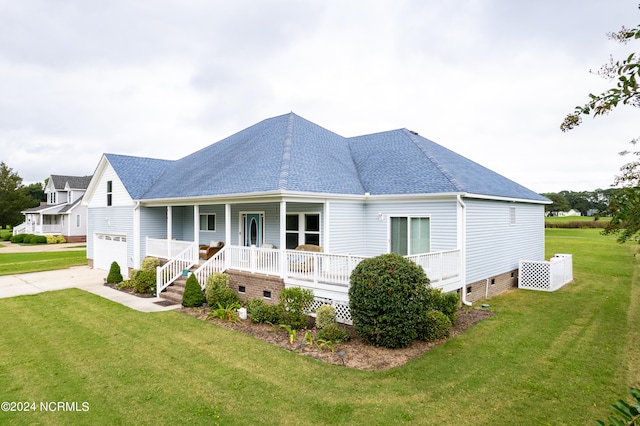 view of front of house with covered porch, a front yard, and a garage