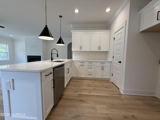 kitchen with kitchen peninsula, sink, decorative light fixtures, dishwasher, and white cabinetry