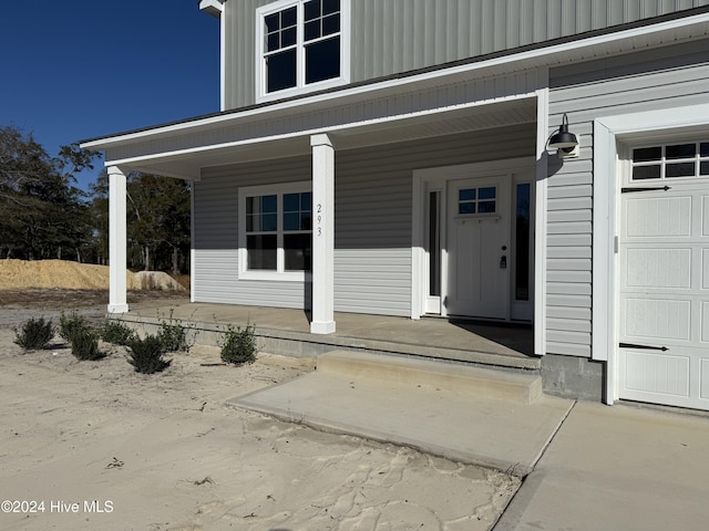 property entrance featuring a porch and a garage