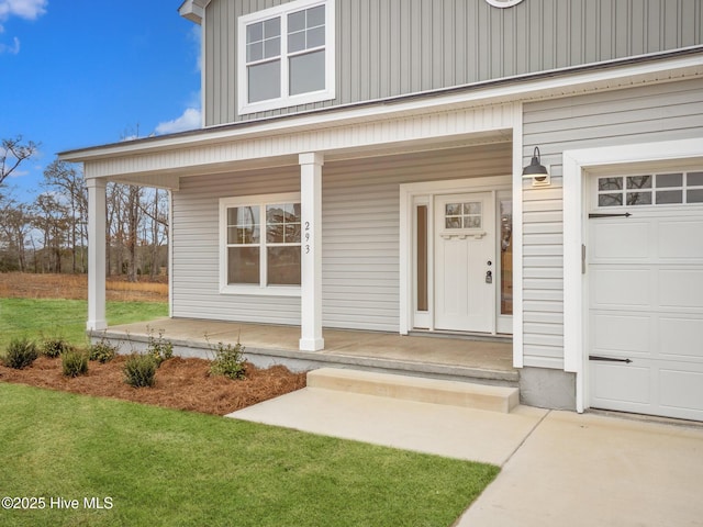 entrance to property with a yard, a garage, and a porch